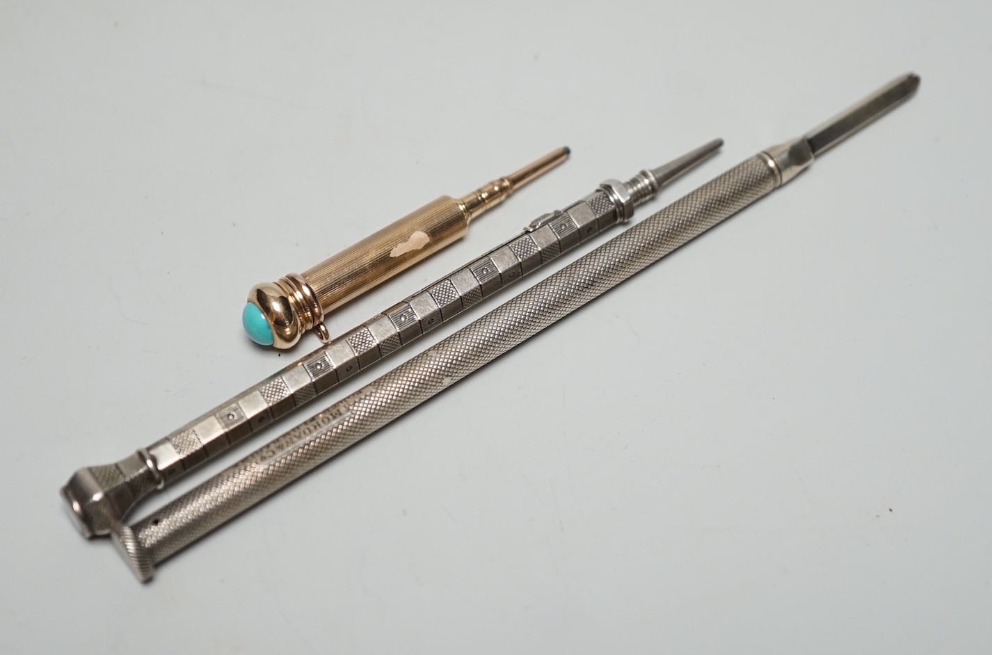 Two silver pencils and a turquoise set propelling pencil